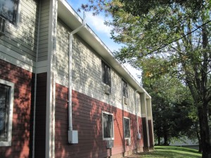 Side of a red and white home with mitigation system