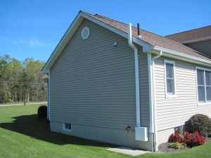 Side of a white/tan home with mitigation system